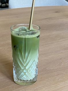 a glass filled with liquid sitting on top of a wooden table