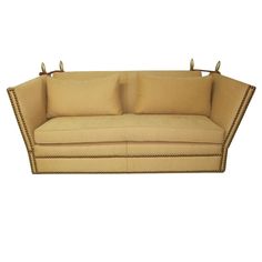 a beige couch with two pillows on it's back and one pillow in the middle