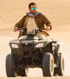 a man riding an atv in the desert