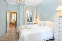 a bedroom with blue walls and white furniture