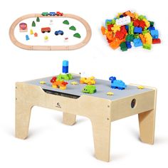 a child's wooden table with legos on it and a toy train set in the background