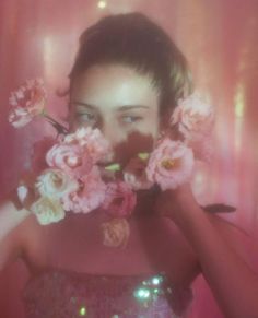 a woman holding flowers in front of her face