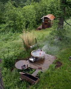 an outdoor hot tub surrounded by trees and grass