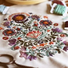 a close up of a piece of cloth with scissors and thread on the table next to it