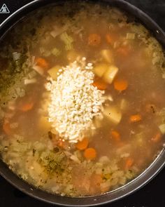 a pot filled with soup and rice on top of a stove