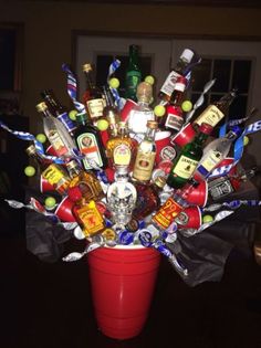 a red vase filled with lots of liquor bottles