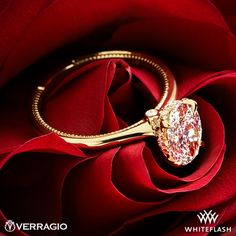 a diamond ring sitting on top of a red rose