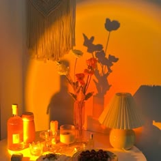 a table topped with candles and flowers next to a vase filled with flowers on top of a table