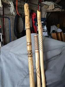 two carved wooden poles sitting next to each other on top of a white cloth covered table