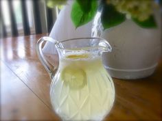 a pitcher filled with liquid sitting on top of a wooden table