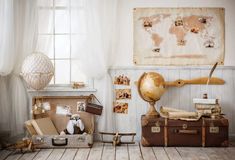 old suitcases and other items sit on the floor in front of a wall with a world map