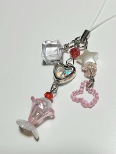 a keychain with charms attached to it on a white surface, including a heart and star