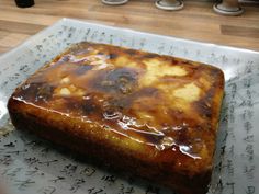 a piece of cake sitting on top of a pan covered in wax paper and caramel sauce