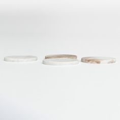 three pieces of white marble sitting on top of each other in front of a white wall