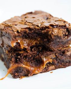 two chocolate brownies stacked on top of each other with caramel drizzle