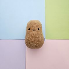 a stuffed animal is sitting on top of a colorful wall with pastel colors in the background