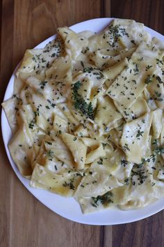 a white plate topped with pasta covered in cheese