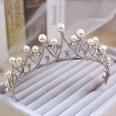 a tiara with pearls on it sitting in a box