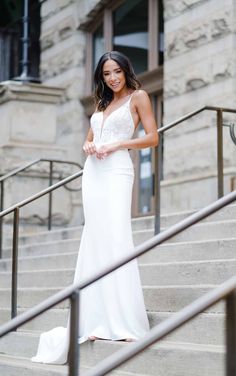 a woman in a white dress standing on some steps