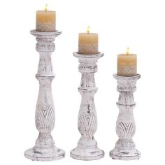 three white candles sitting next to each other