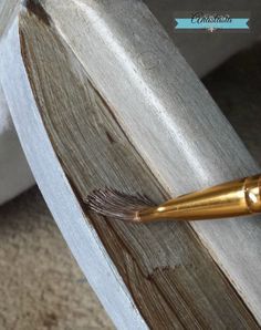 a close up of a wooden chair with a gold pen on the top of it