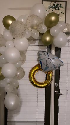 the balloon arch is decorated with gold and white balloons