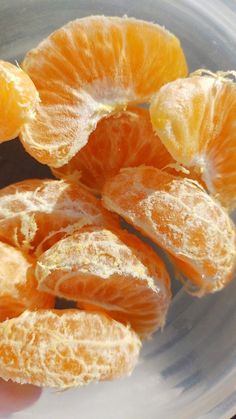 peeled oranges sitting in a bowl on top of a table