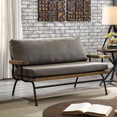 a gray couch sitting in front of a brick wall