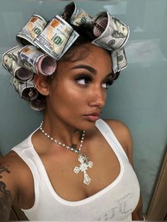 a woman with lots of money on her head, wearing a necklace and white tank top