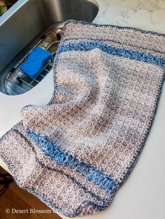 a crocheted dishcloth sitting on top of a kitchen counter next to a sink