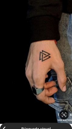 a person with a small triangle tattoo on their left hand and the word love written in it