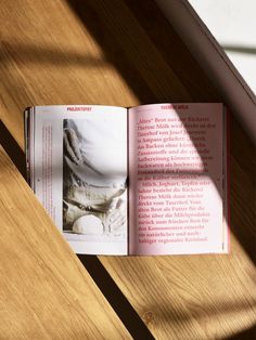 an open book sitting on top of a wooden table