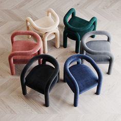 six different colored chairs sitting on top of a hard wood floor next to each other