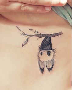 a woman's chest with a small bird wearing a witches hat on her head