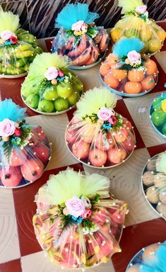 several baskets filled with fruit on top of a checkered tablecloth covered flooring