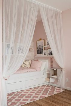 a bedroom with pink walls and white curtains