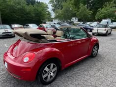 a red convertible car parked in a parking lot