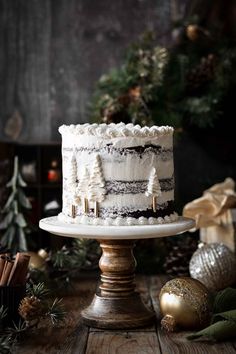 High altitude chocolate gingerbread cake that’s soft and moist, with cozy winter spices and a hint of molasses and coffee, frosted with fluffy vanilla buttercream. This beautiful cake looks lovely with a semi-naked coat of snowy buttercream decorated with piped evergreen trees for the Christmas holiday.