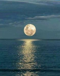 the full moon shines brightly in the sky over the ocean as it reflects on the water