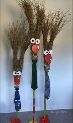 three scarecrows made out of sticks with ties and hats hanging from the top