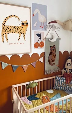 a baby crib with stuffed animals and pictures on the wall