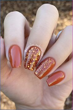 The autumn is here, and it’s time for orange nails to shine. Orange is the main color of fall, meaning it’s the perfect nail color for this season. It’s a very versatile color, too. Depending on your preferences, orange manicures can be bold and dramatic or subtle and chic. The best way to celebrate a new season is to treat yourself to a fresh manicure, so check out this list! Fall Nail Ideas Burnt Orange, Rust Glitter Nails, Burnt Orange And Tan Nails, Orange Glitter Nails Fall, Orange Nails With Gold Flakes, Sparkly Burnt Orange Nails, Harvest Nails Designs, Fall Almond Shape Nail Ideas, Amber Orange Nails