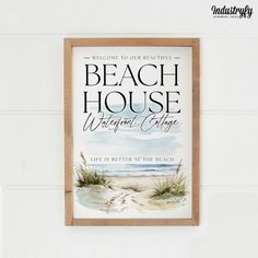 a beach house sign hanging on the wall