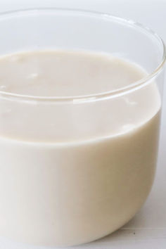 a glass filled with milk sitting on top of a table