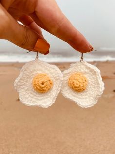 a pair of earrings with two fried eggs on them