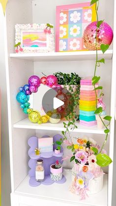 a white book shelf filled with lots of colorful decorations and flowers on top of it