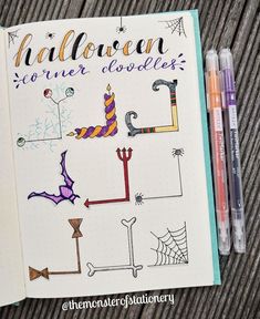 an open notebook with halloween doodles on it and two markers next to the book