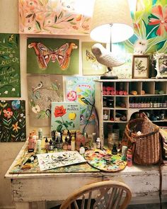 an art studio with lots of paintings on the wall and a lamp in the corner