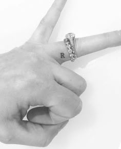 a person's hand with a ring on it and the word rock written in cursive writing