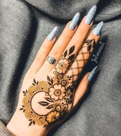 a woman's hand with henna tattoos on it